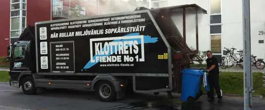 Sopkärlstvätt som är effektiv med ett fordon Glad arbetare som utför sopkärlstvätt med en sopkärlsbil