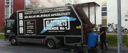 Glad arbetare som utför sopkärlstvätt med en sopkärlsbil